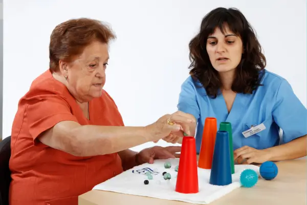 Terapeuta ocupacional auxiliando criança/idoso em atividades cotidianas